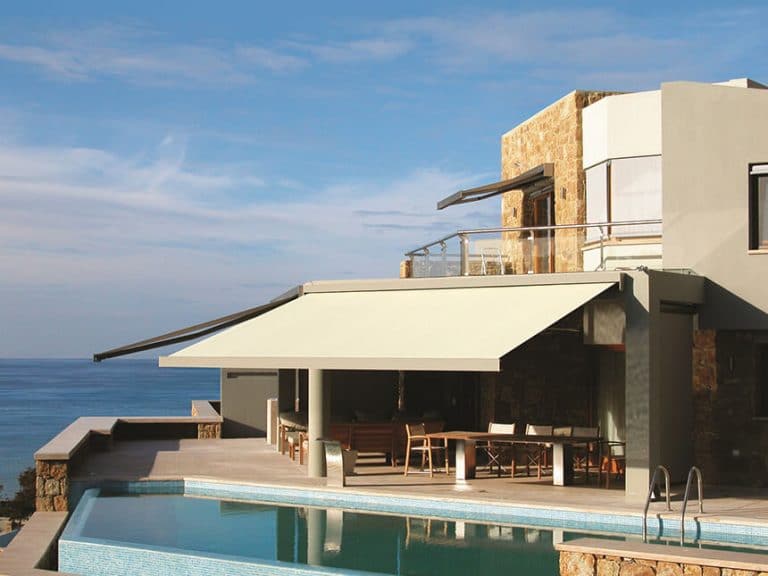 Stylish shutters on a modern coastal home with an outdoor pool, ocean view, and contemporary archite.