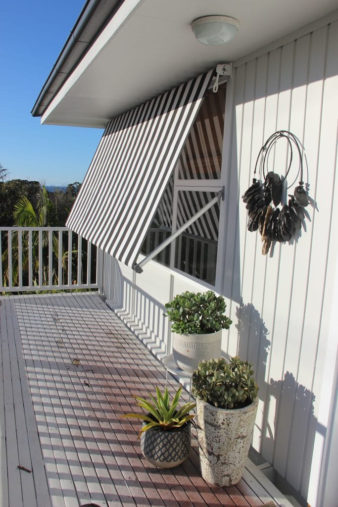 Elegant striped outdoor awning providing shade on a balcony.