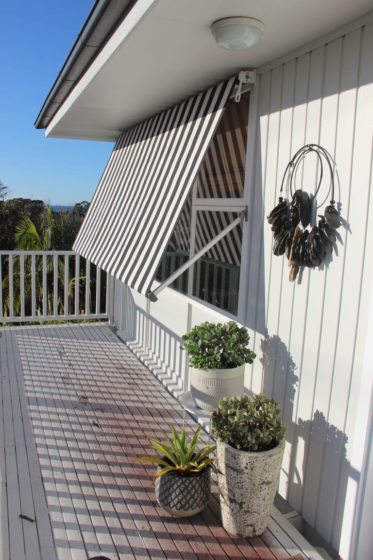 Elegant striped outdoor awning providing shade on a balcony.