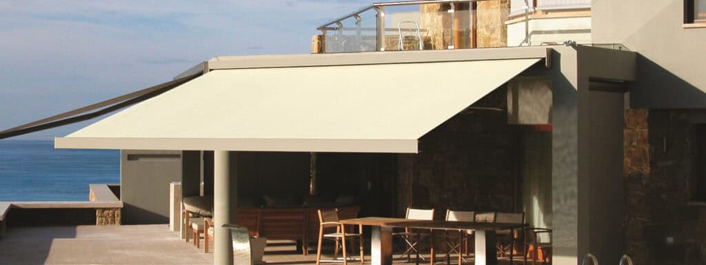Folding arm awning providing shade and weather protection for outdoor living spaces.
