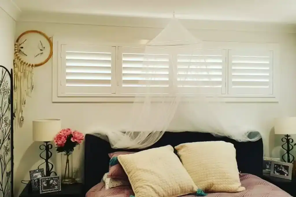 Elegant white shutters in a modern bedroom setting.