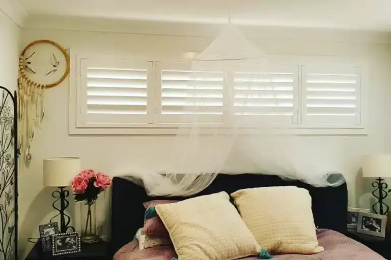 Elegant white shutters in a modern bedroom setting.