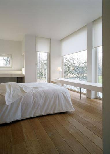 Bright bedroom featuring sleek roller blinds and large windows for natural light.